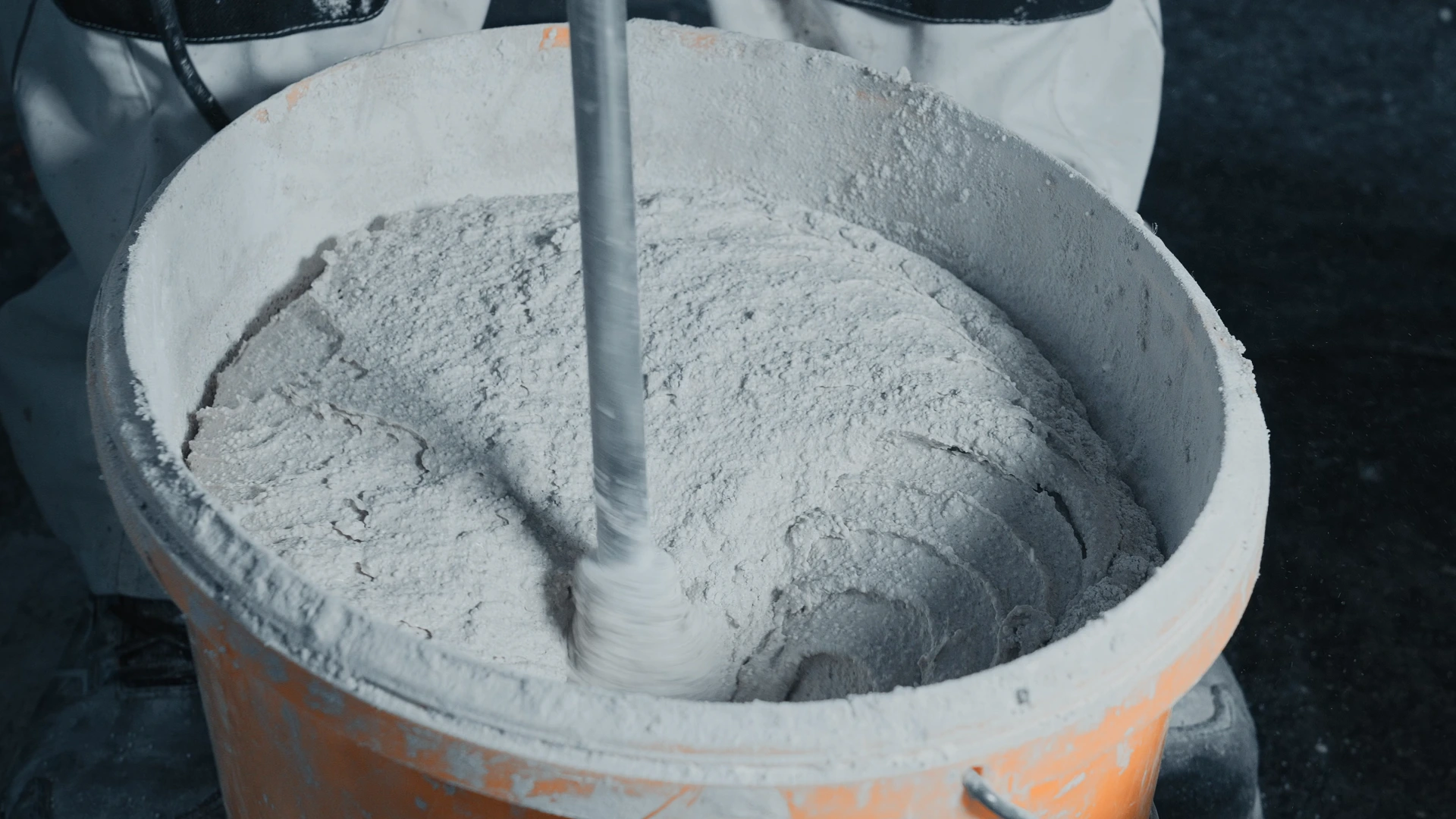 Handwerker rührt Mörtel in einem Eimer an – Schwarzwaldbau GmbH Offenburg, präzise Vorbereitung für Sanierungs- und Putzarbeiten